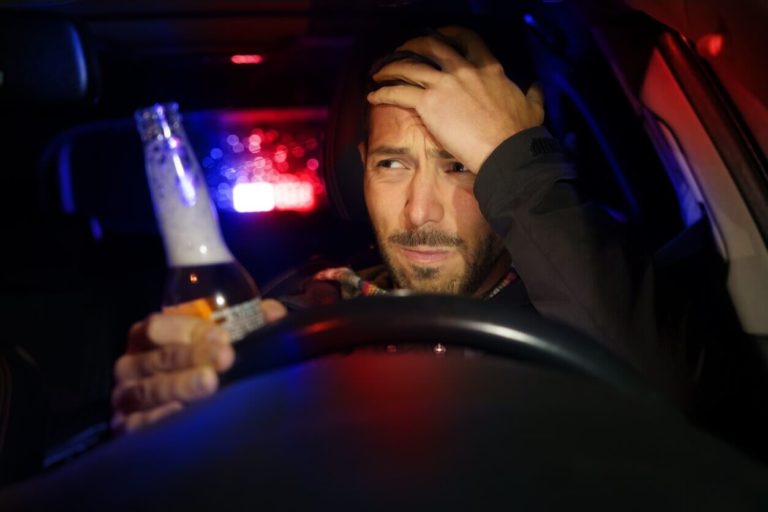 A man involved in a DUI accident looking in his rearview mirror