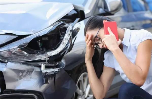 Woman making phone call after car accident